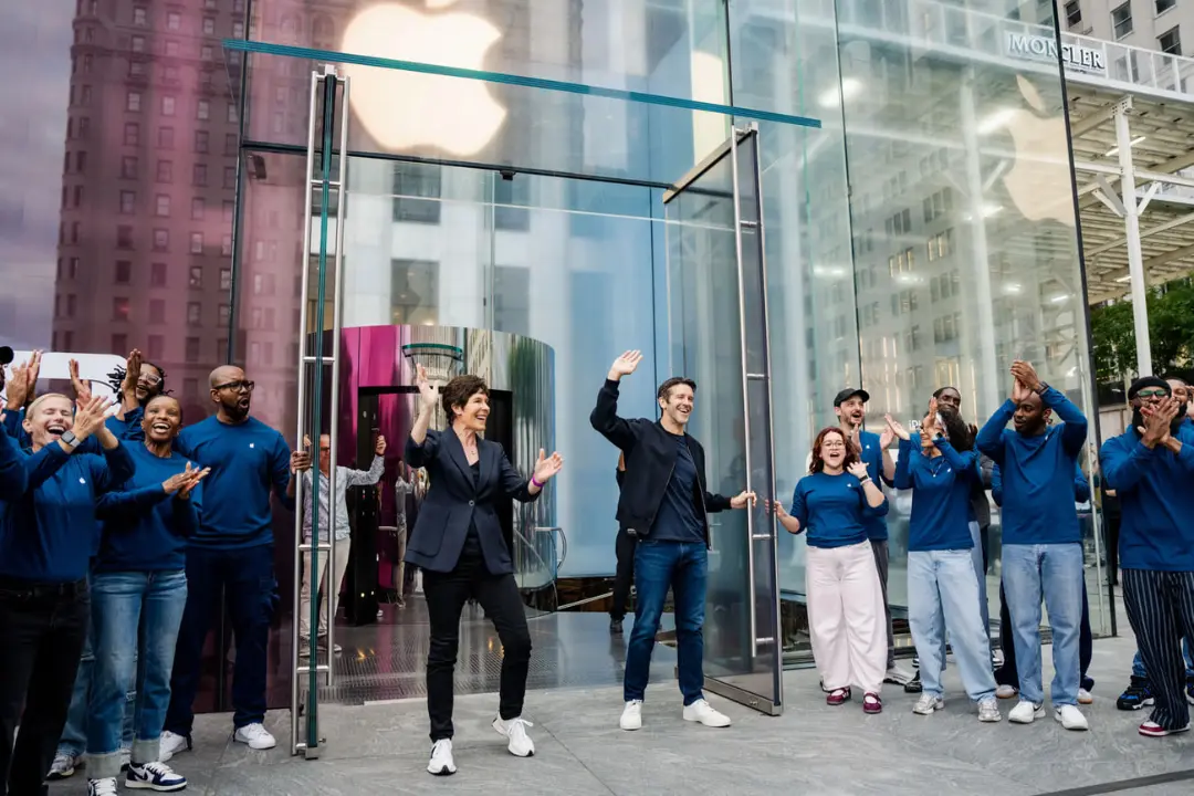 کارکنان اپل (Apple) در مقابل فروشگاه شیشه‌ای در نیویورک در حال جشن گرفتن هستند