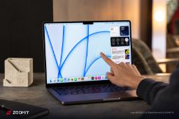 نمای نزدیک از دست کاربر در حال لمس صفحه نمایش لپ‌تاپ اپل (Apple)
