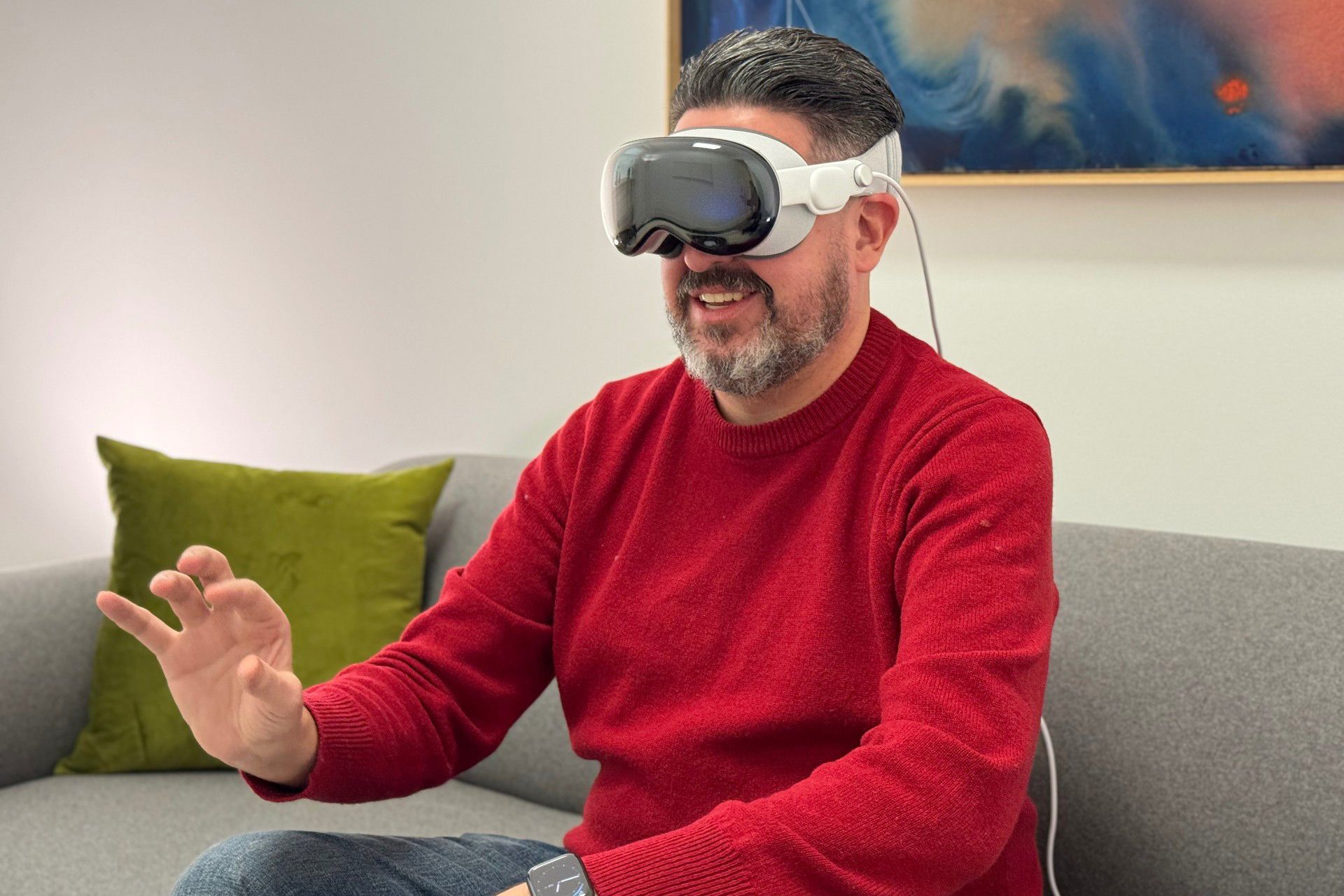 شخصی نشسته روی مبل درحال کار با هدست واقعیت مجازی اپل ویژن پرو