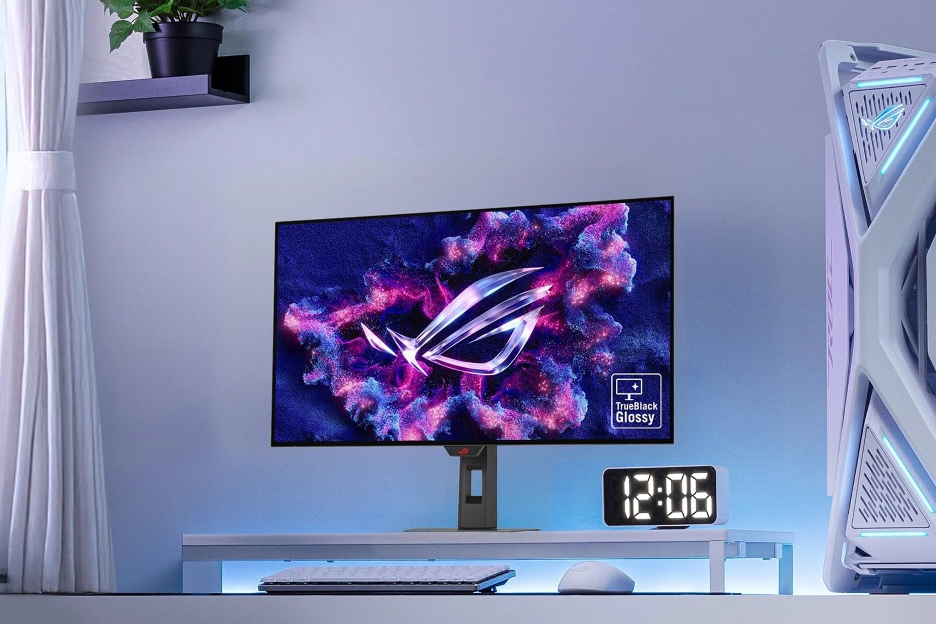 نمای جلو مانیتور گیمینگ ROG Strix ایسوس روی میز کنار ساعت دیجیتال