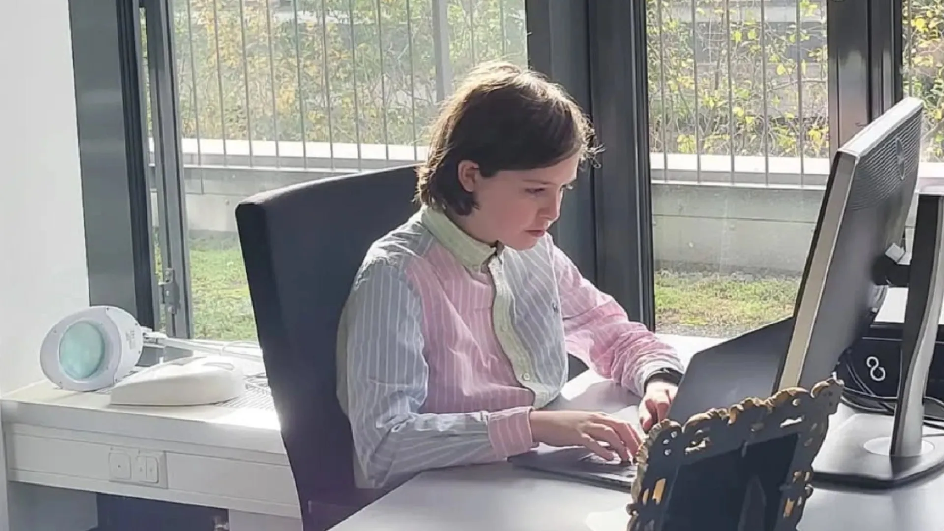 یک نوجوان ۱۵ ساله پشت میز درحال کار با لپ‌تاپ