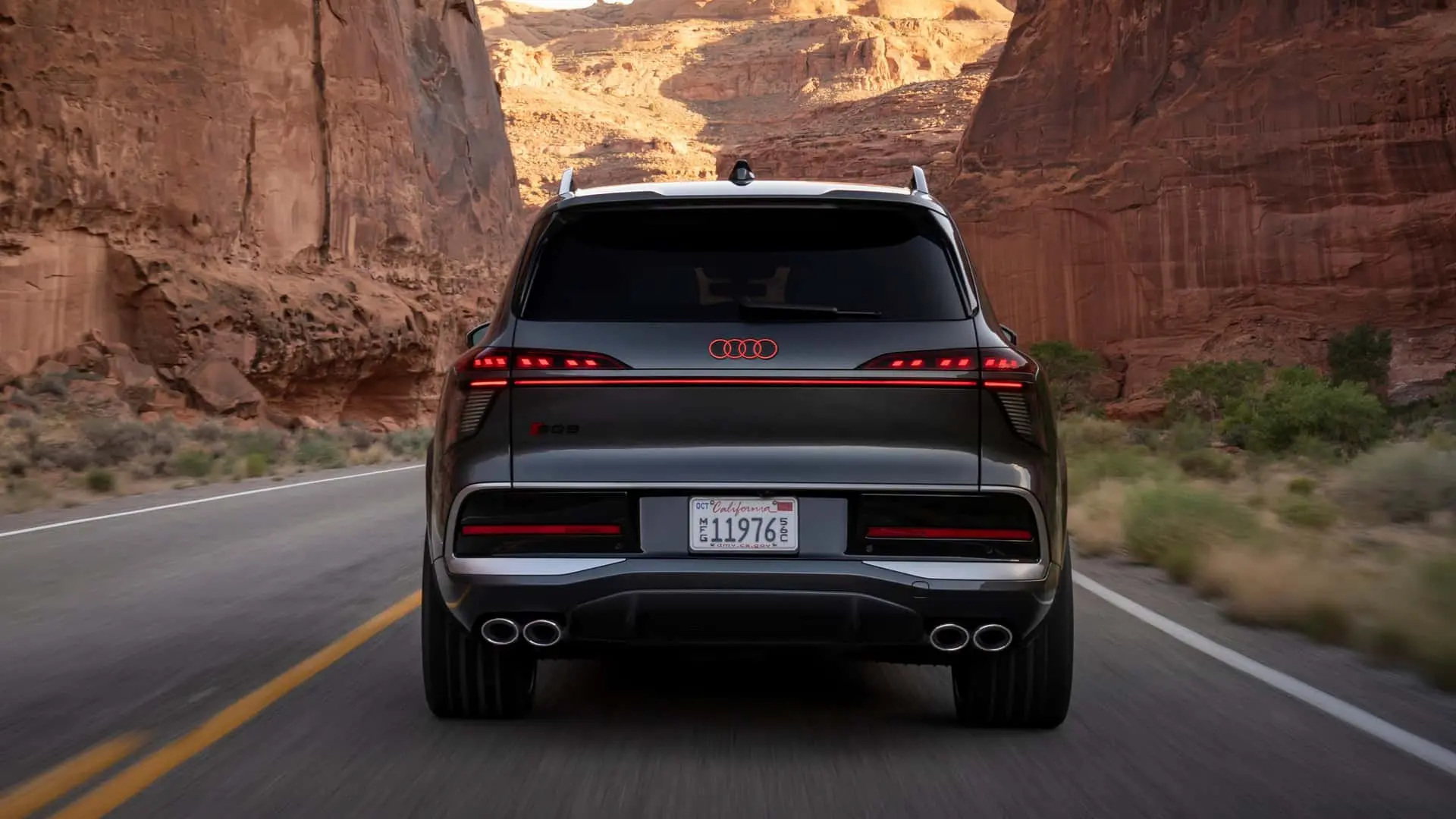 نمای عقب خودروی شاسیبلند آئودی (Audi) در جادهای میان درههای سنگی