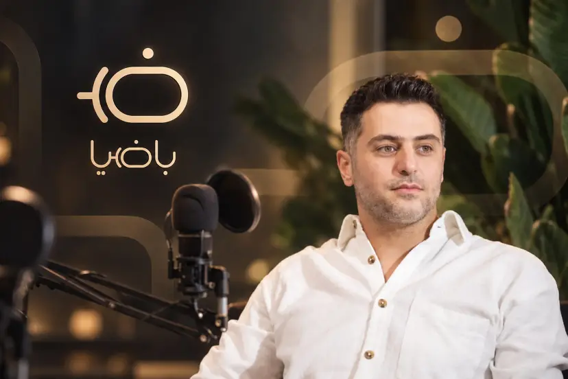 علی ضیا در مقابل میکروفون در استودیوی پادکست