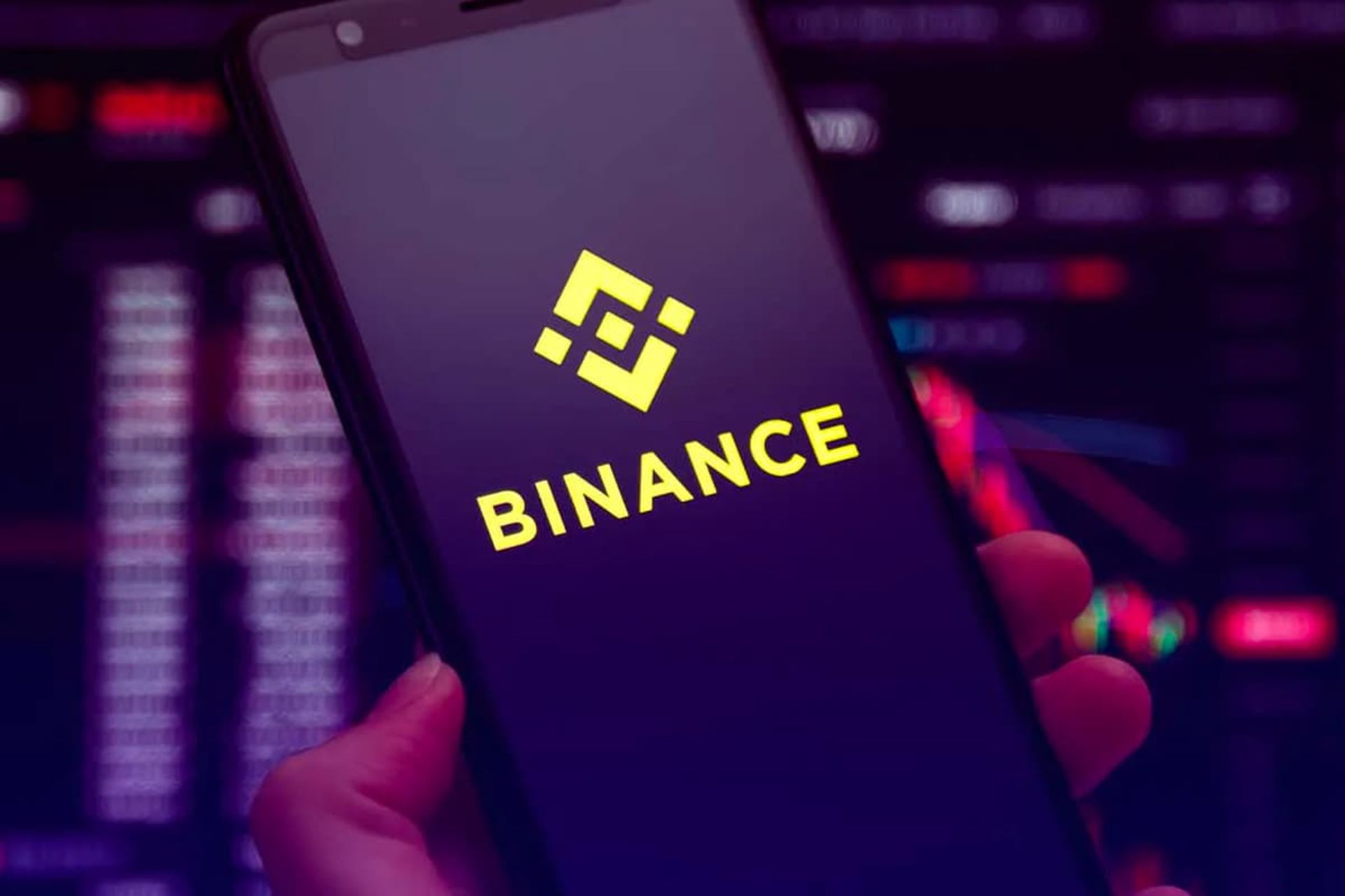 لوگو بایننس / Binance روی گوشی هوشمند در دست