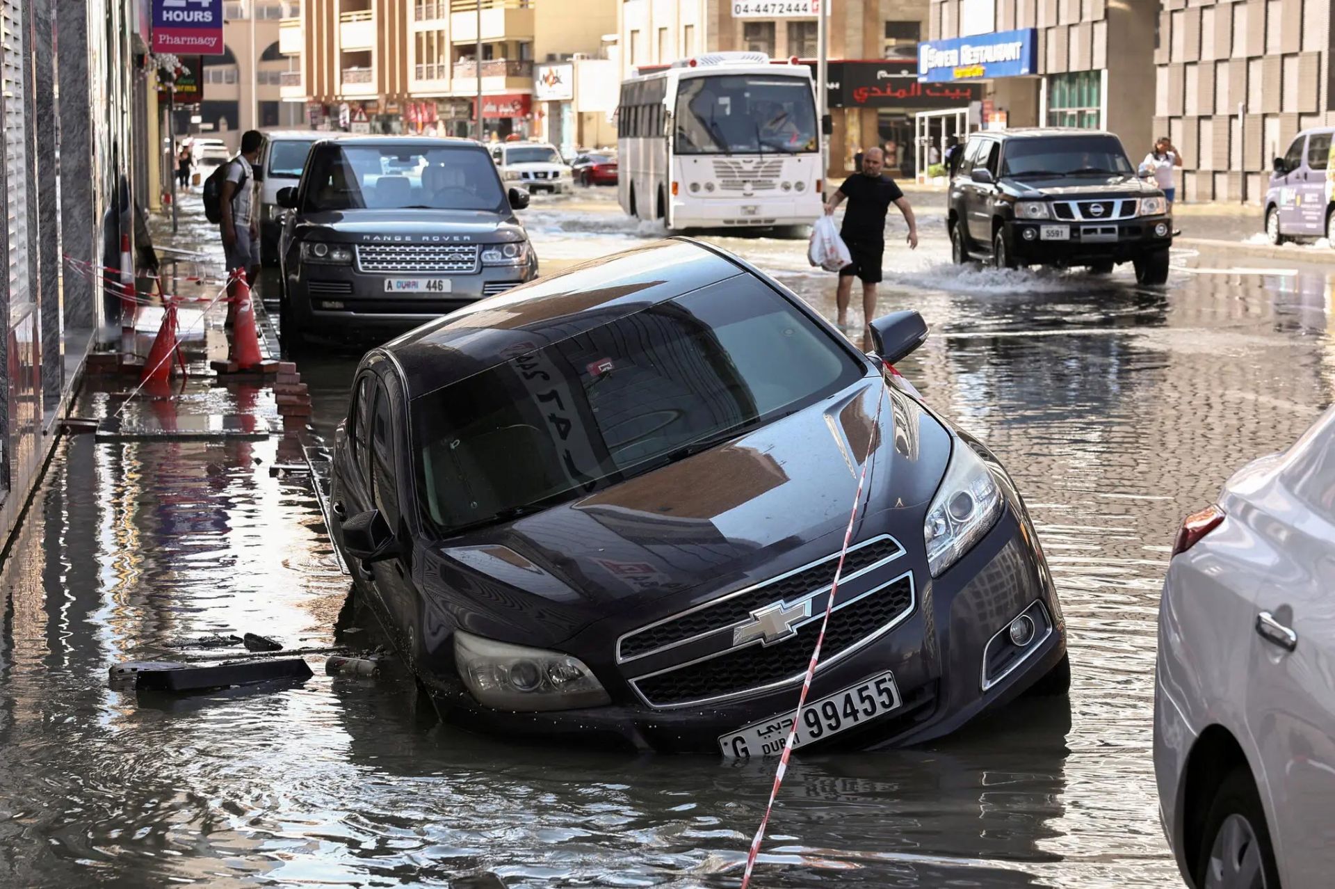 خودرو سدان مشکی تا حدی در سیلاب فرو رفته است