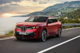 شاسی‌بلند برقی BMW iX4 در حال حرکت در جاده ساحلی