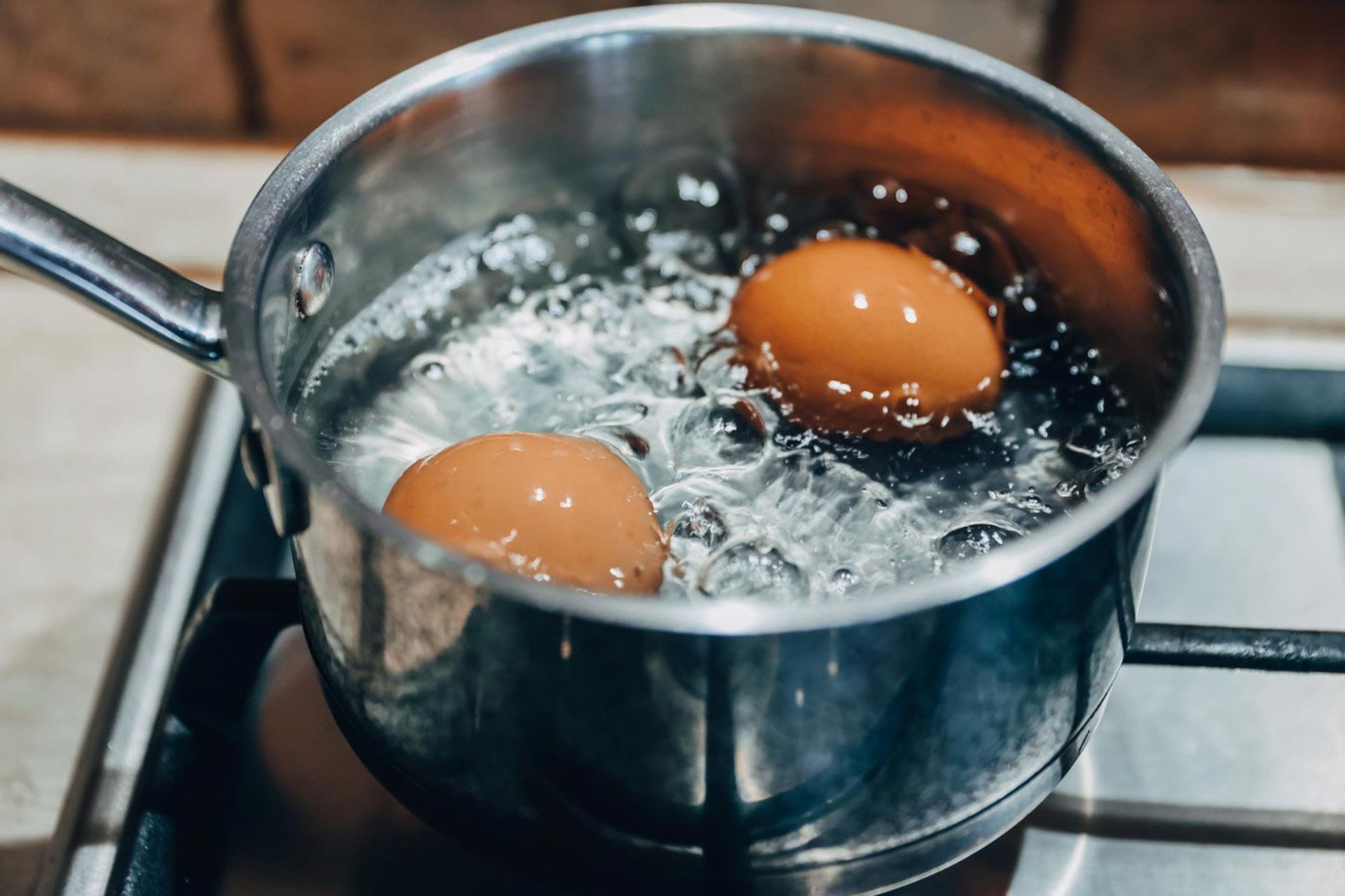 دو تخم مرغ محلی درحال پختن در ظرف آب جوش