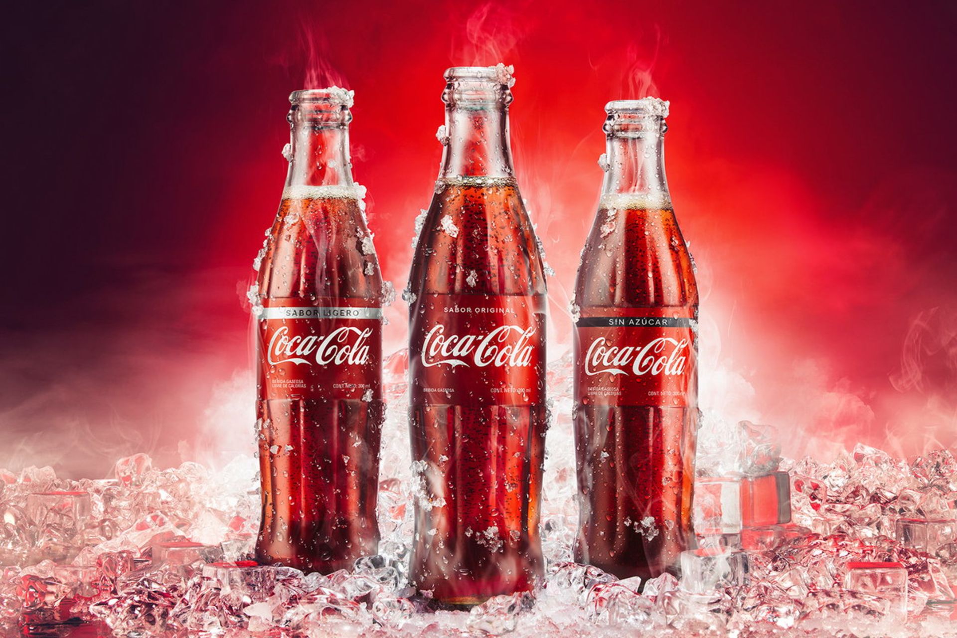 سه بطری کوکاکولا روی یخ با پس‌زمینه قرمز