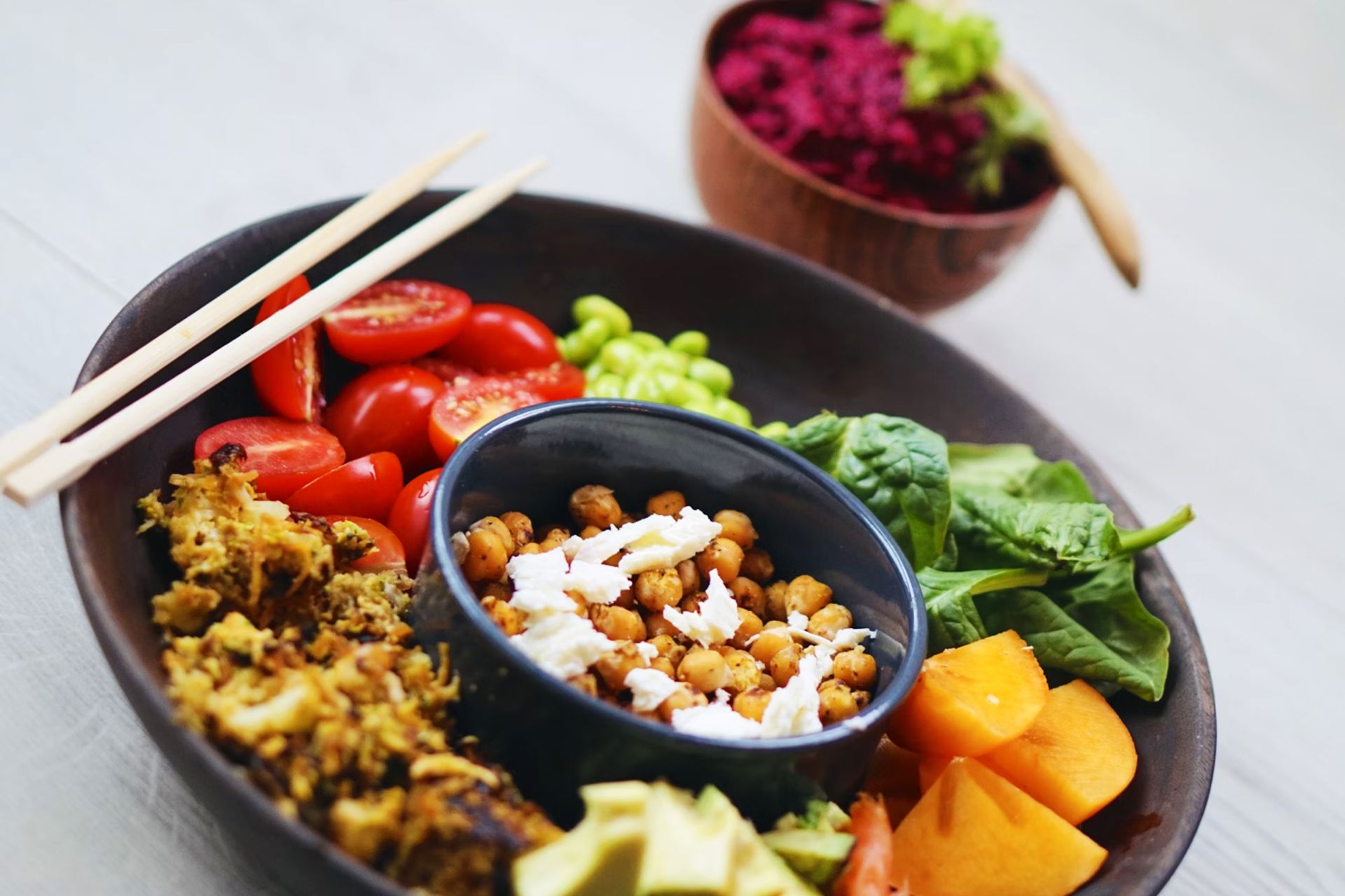 بشقابی مشکی از غذاهای سالم، سبزیجات و میوه و حبوبات