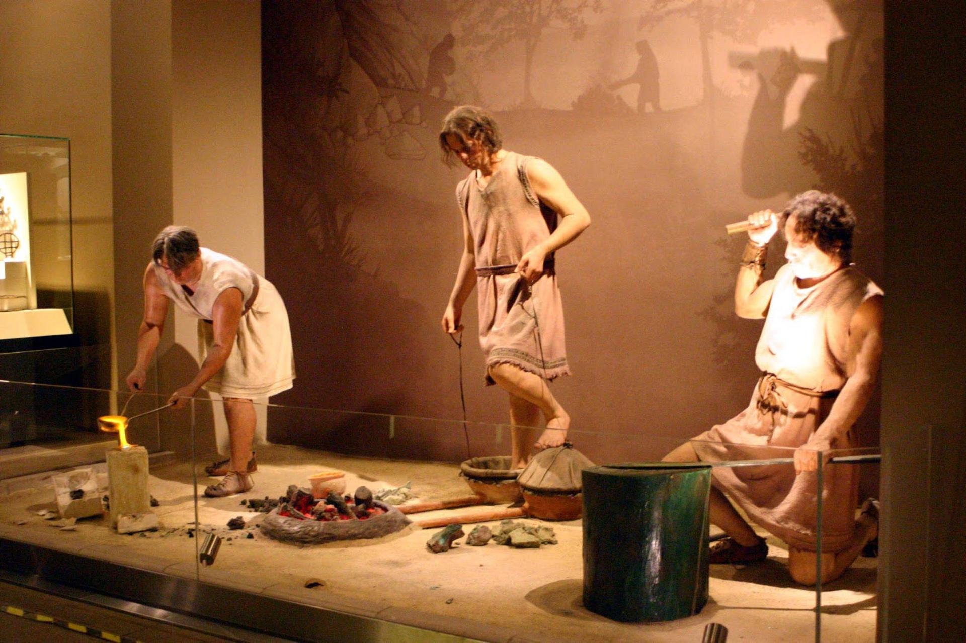 مجسمه سه مرد باستانی از عصر برنز که درحال ریخته‌‌گری، ذوب و شکل‌دهی به فلزات هستند