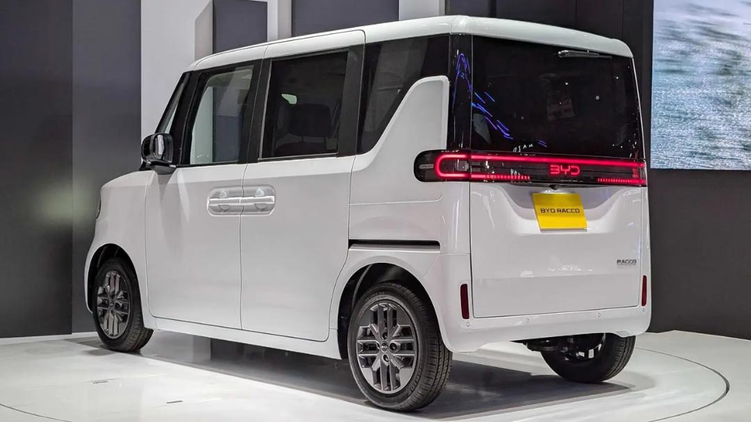 نمای پشت و نیم‌رخ خودروی برقی سفید رنگ مدل BYD RACCO در یک نمایشگاه خودرو