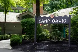 تابلوی چوبی سیاه رنگ با نوشته سفید نام کمپ دیوید (Camp David)