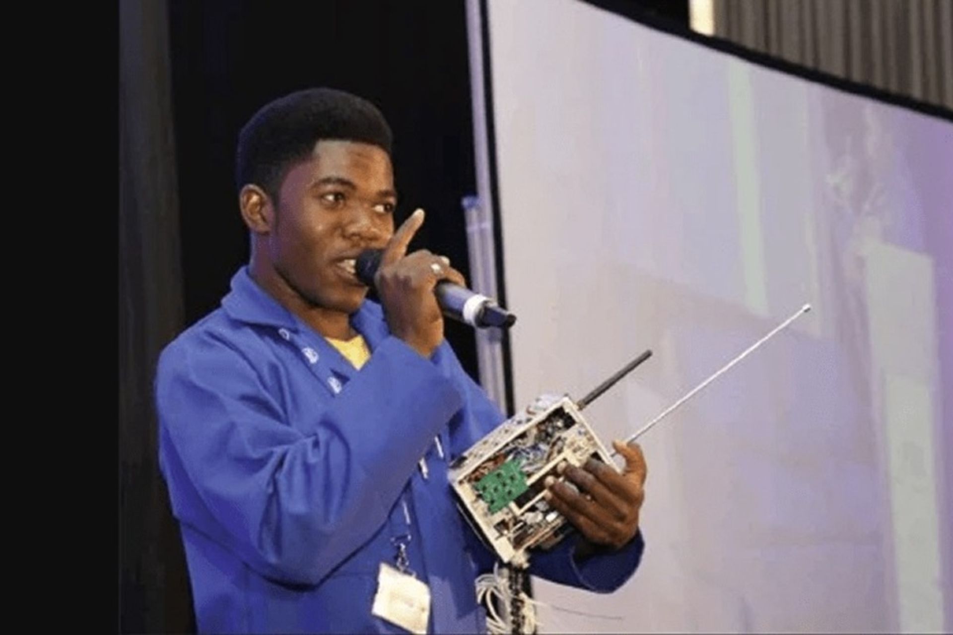 یک جوان آفریقایی در حال معرفی اختراح روی صحنه