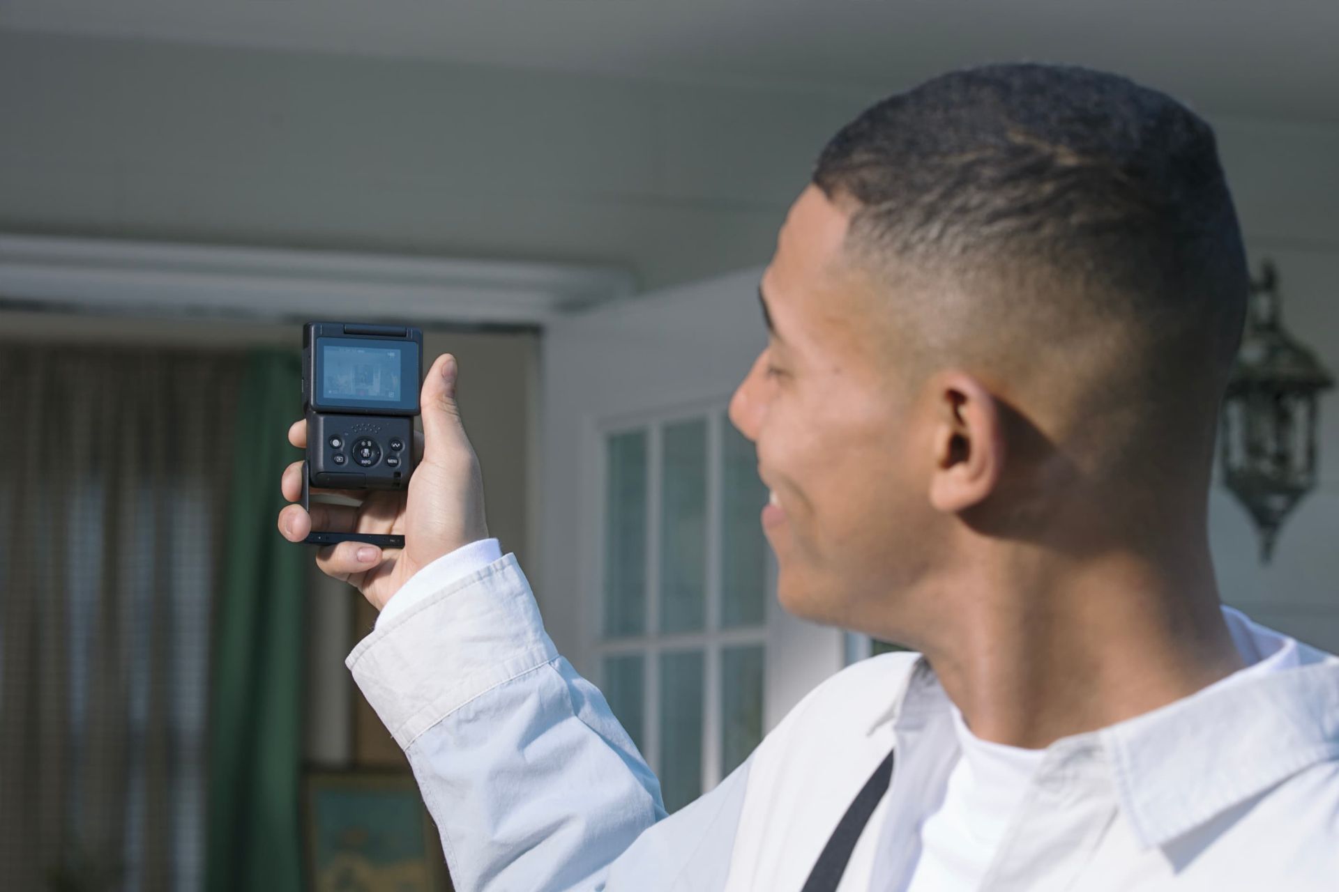 دوربین ولاگ کانن V10 در دست مرد سیاه پوست