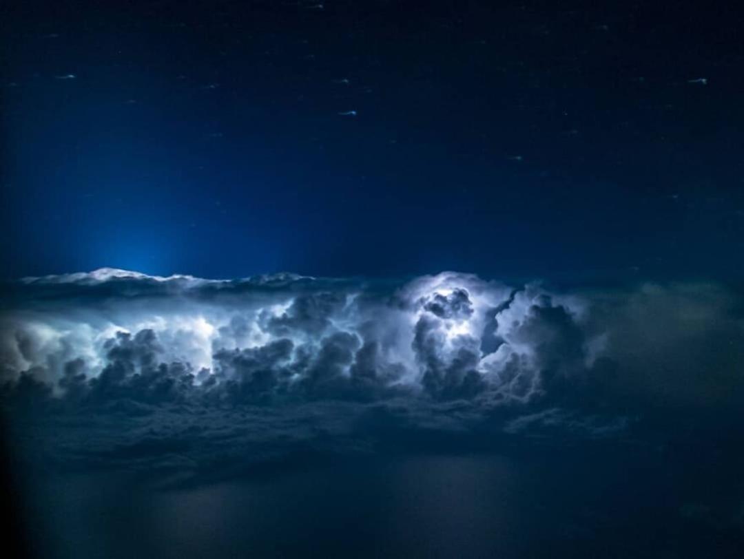 آسمان شب از پنجره هواپیما ابرها