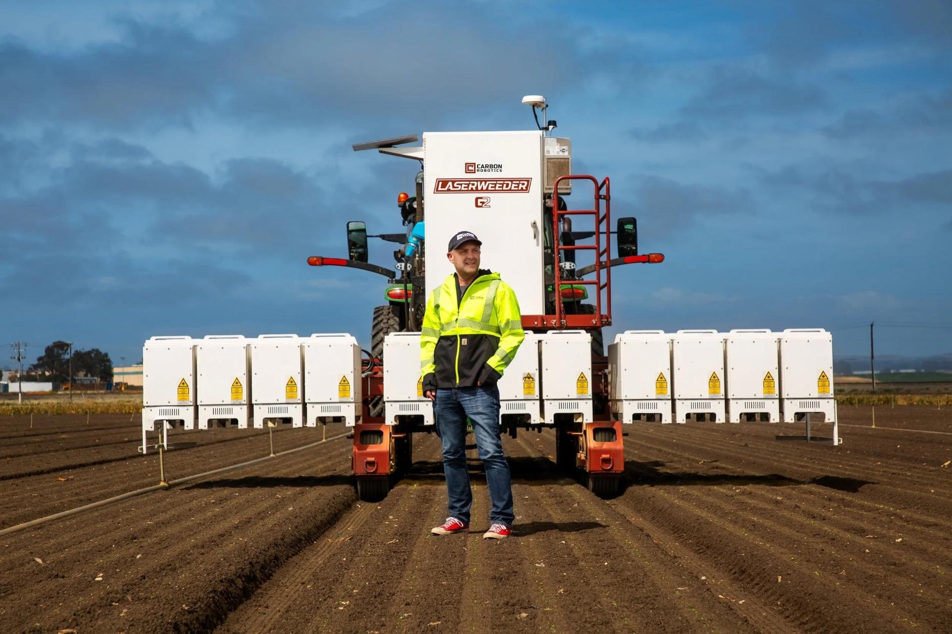 مردی جلو دستگاه لیزرویدر کربن رباتیکس در زمین کشاورزی