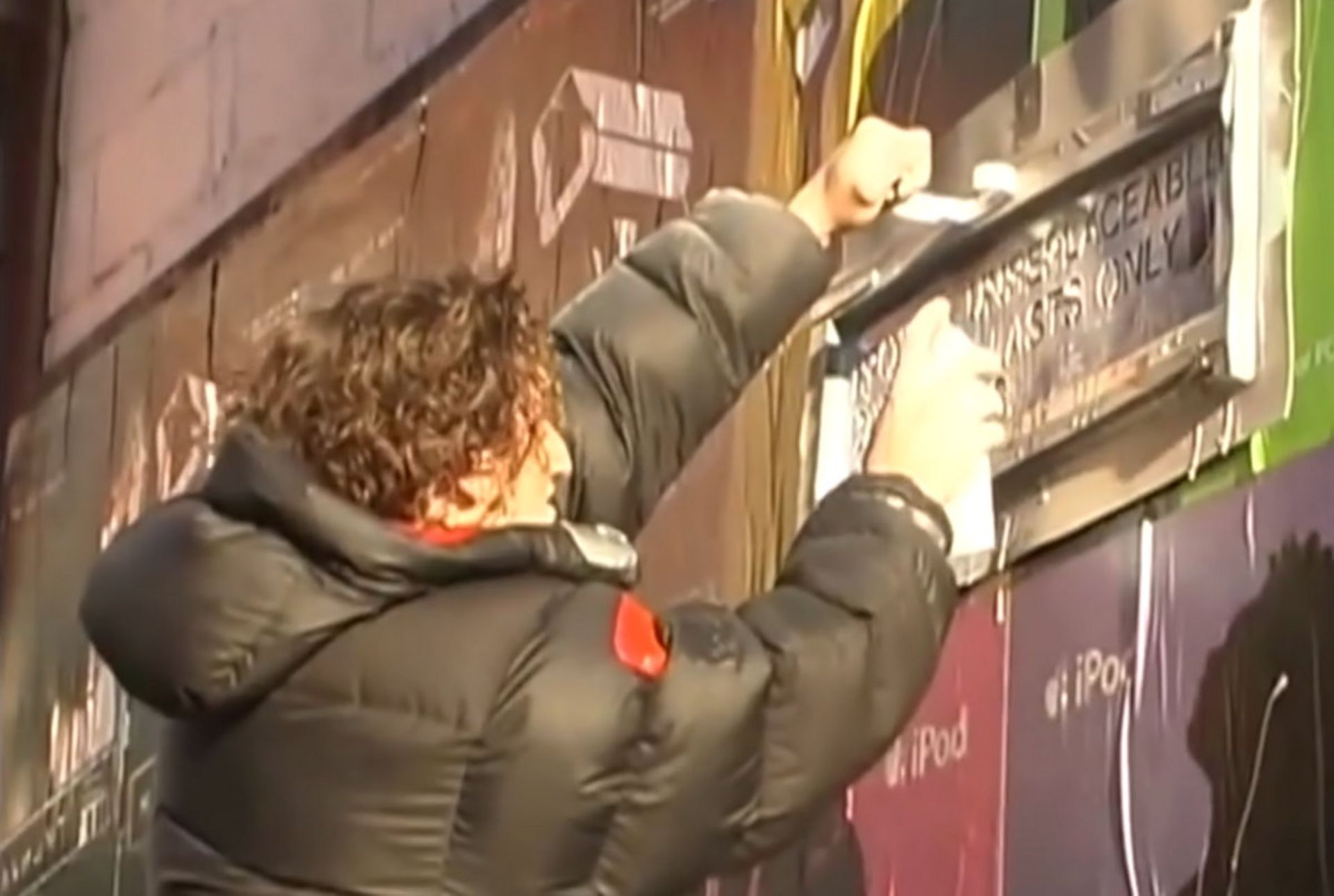 کیسی نایستت جوانی در حال نوشتن با اسپری رنگ روی دیوار