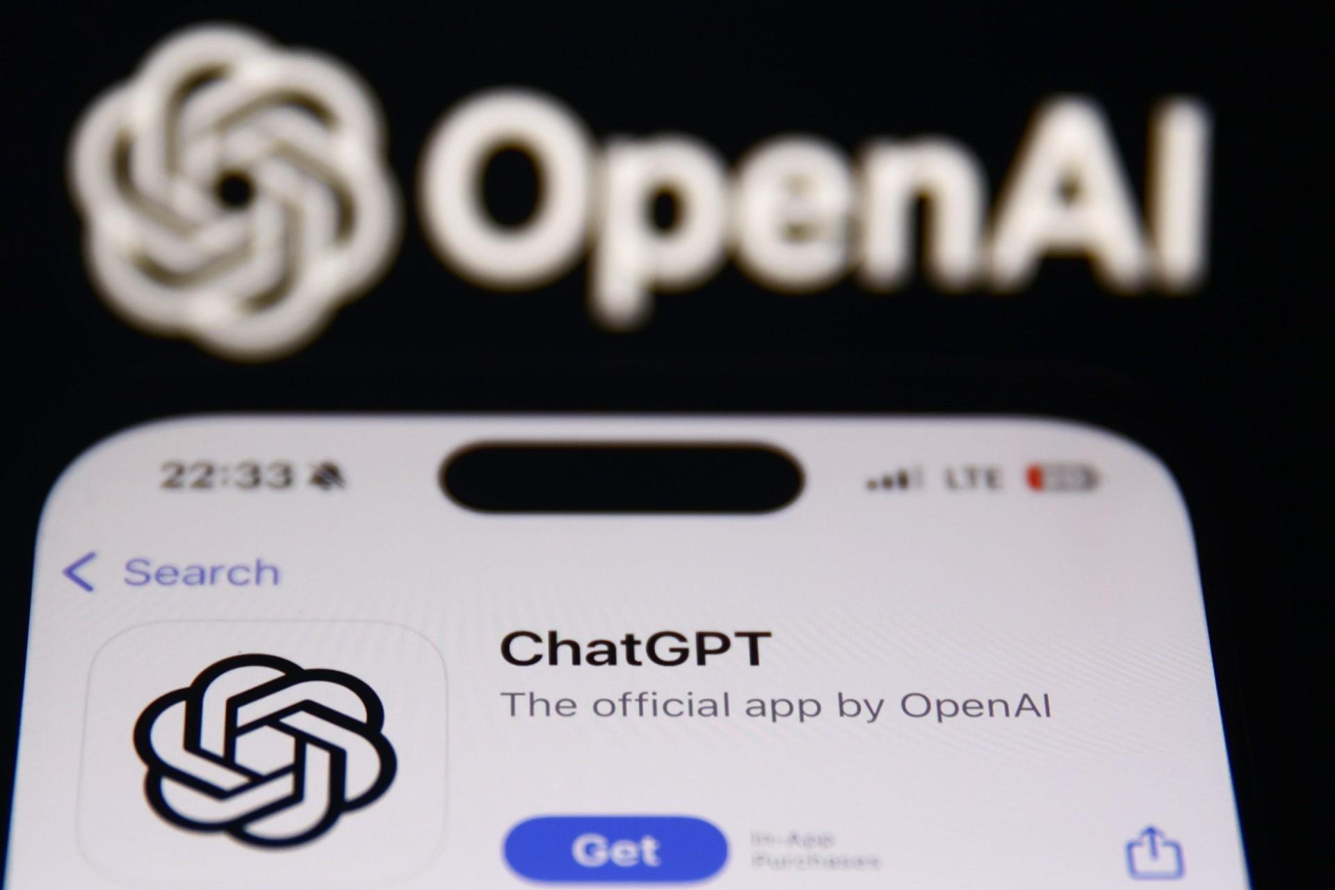 لوگو ChatGPT روی نمایشگر آیفون در پس‌زمینه‌ی لوگو OpenAI