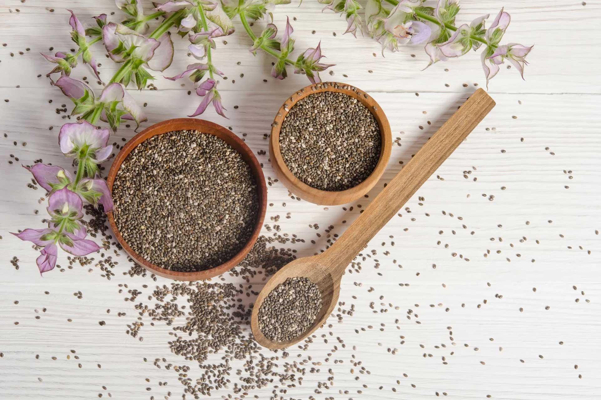 دانه چیا درون ظروف چوبی در کنار گیاه چیا