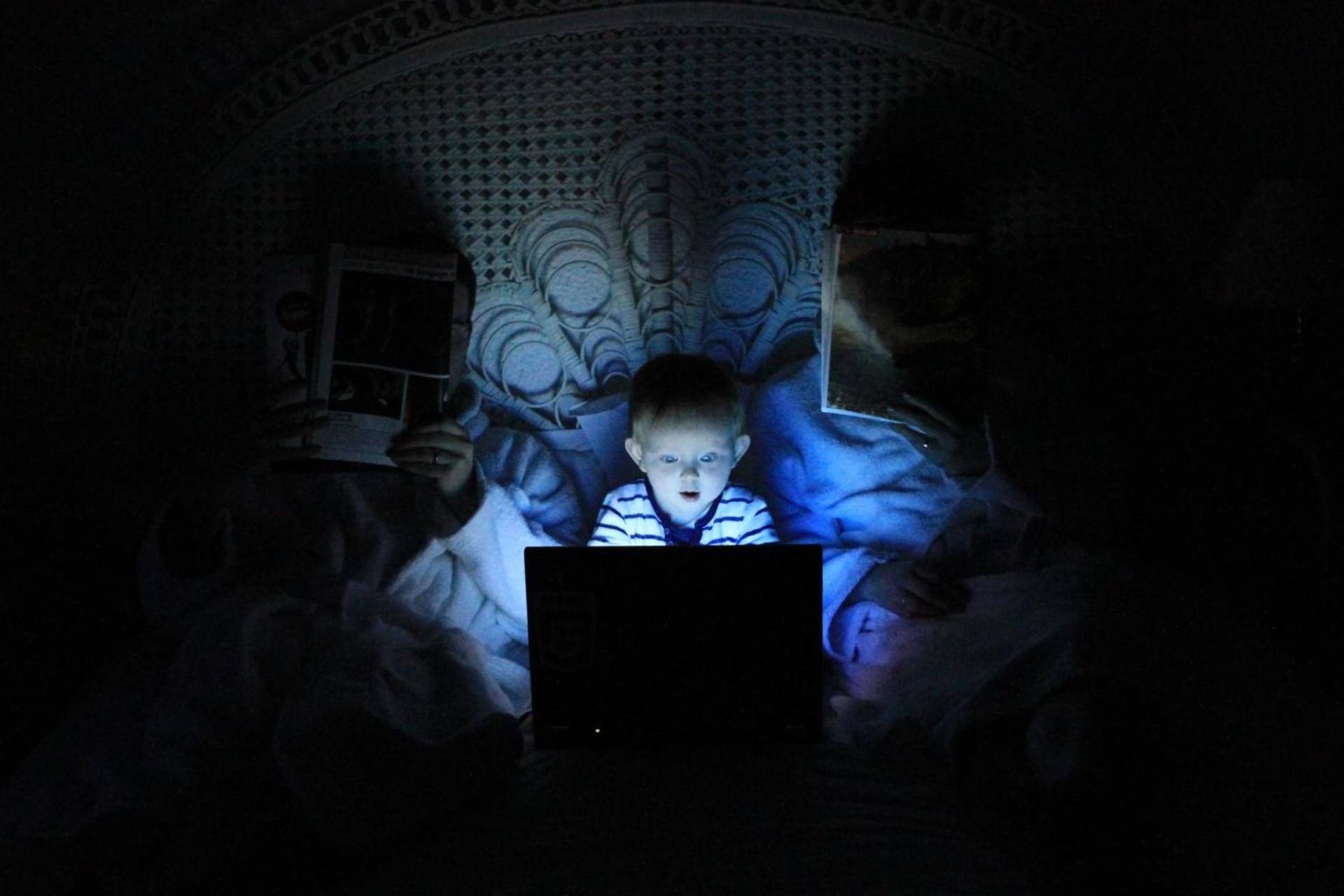 کودک درحال کار با کامپیوتر در تاریکی