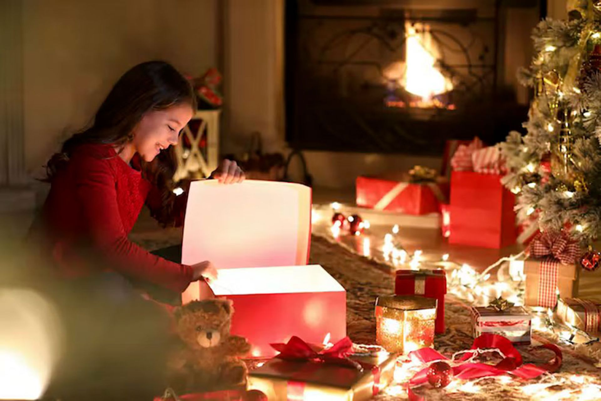 دختری در حال باز کردن کادوهای کریسمس