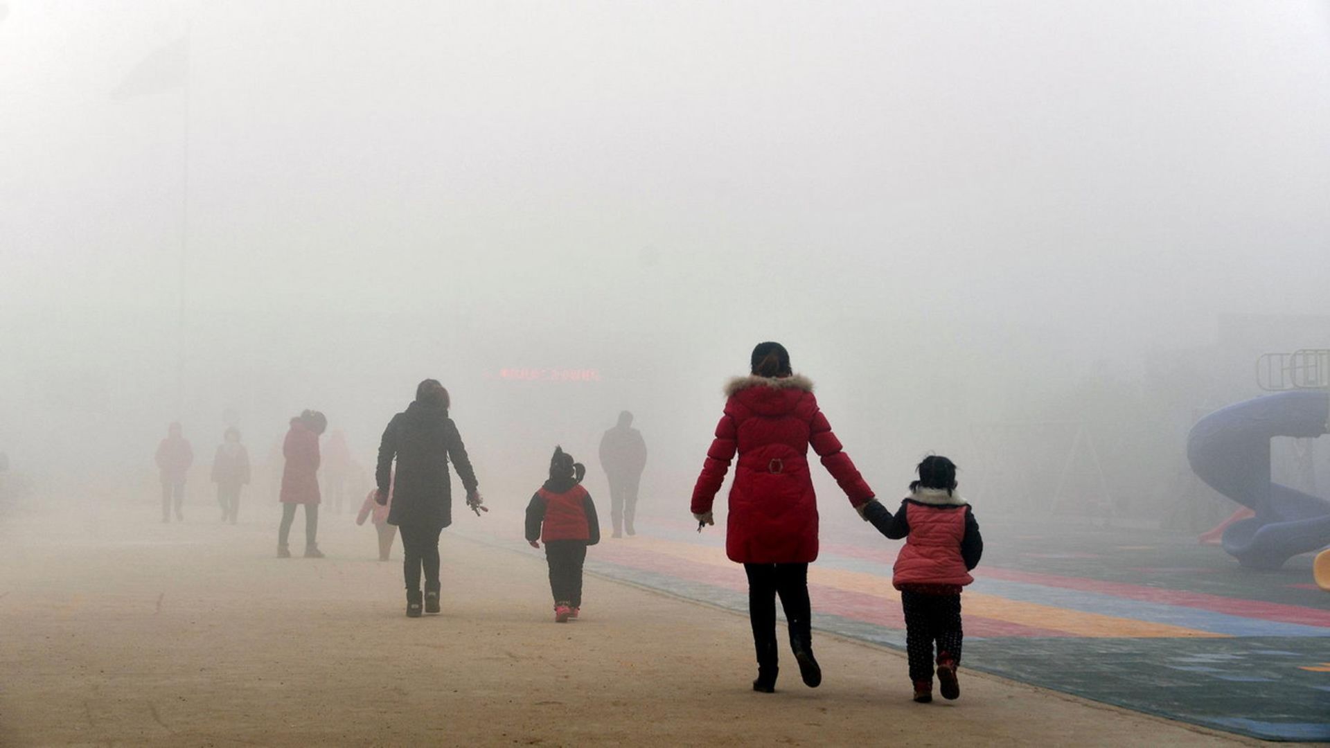 مادر و فرزند در حال راه رفتن در خیابان در هوای آلوده