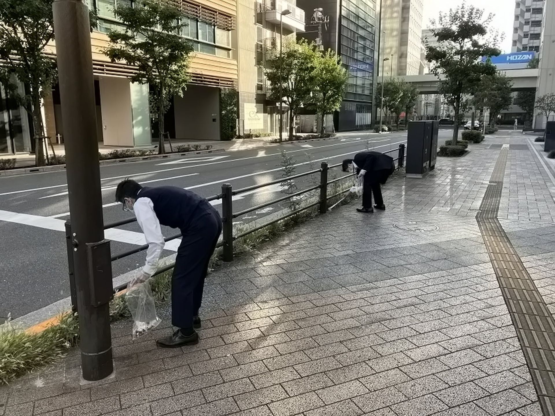 مردم ژاپن در حال تمیز کردن پیاده‌رو اطراف محل کار