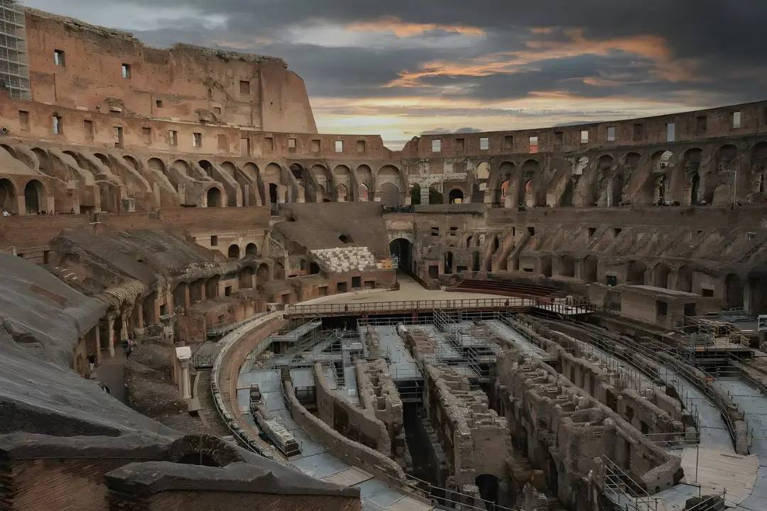 ساختمان باستانی کولوسئوم (Colosseum) در رم با دیواره‌های آجری و سکوهای قدیمی