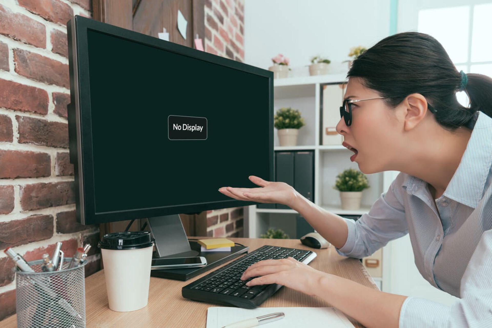 یک زن عصبانی در حال نگاه کردن به کامپیوتر خاموش