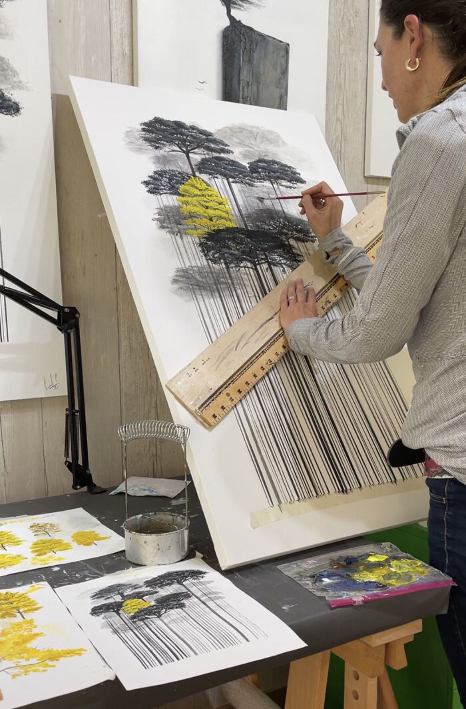 نقاش در حال نقاشی درخت‌های سبز و زرد بارکدی