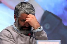 تصویر چهره نگران و متفکر پژمان جمشیدی در حالی که دست خود را روی پیشانی گذاشته است.