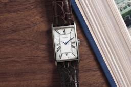 ساعت مچی مستطیلی تایمکس (Timex) با صفحه سفید و بند چرمی قهوه‌ای