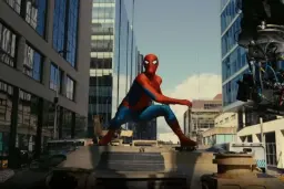 مرد عنکبوتی (Spider-Man) در حالت ایستاده روی بدنه یک تانک در محیط شهری