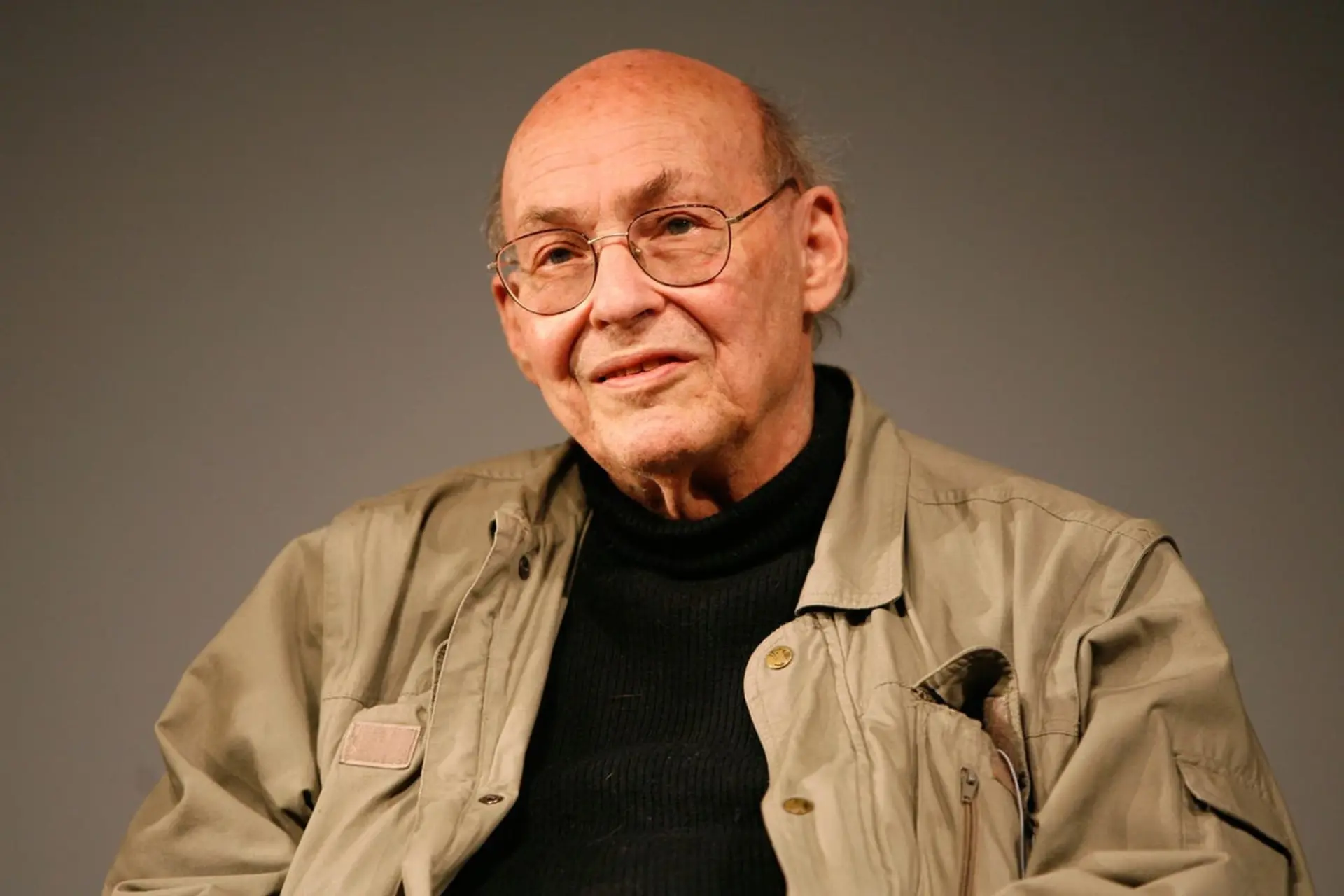 ماروین مینسکی (Marvin Minsky) با عینک و لباس کژوال در برابر پس‌زمینه ساده