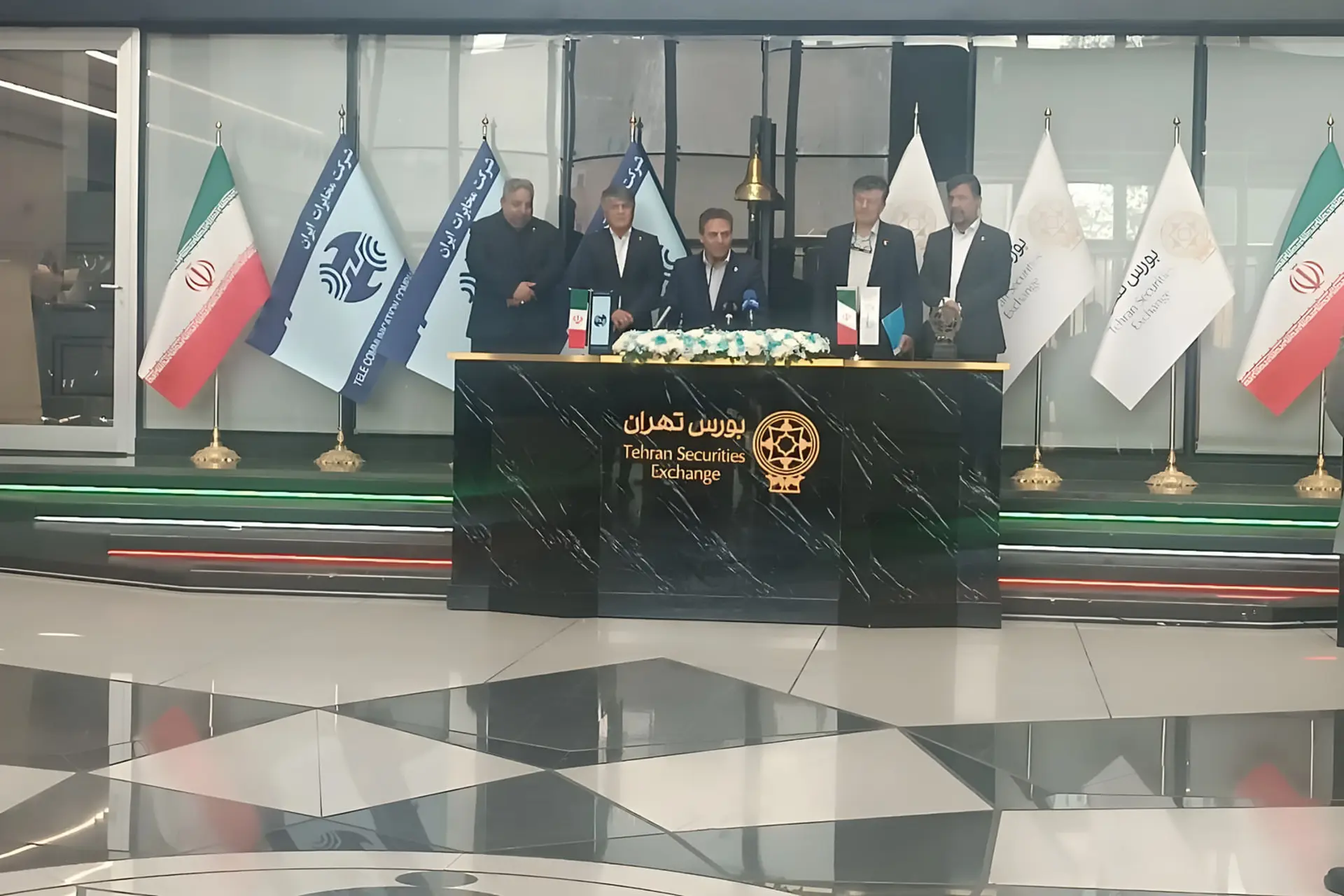 گروهی از مدیران در پشت میز بورس تهران (Tehran Securities Exchange) نشست کرده‌اند
