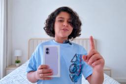 باکس گوشی سامسونگ (Samsung) در دست کودکی با تیشرت آبی