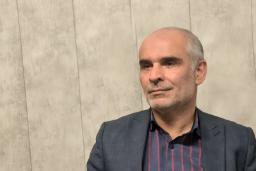 مردی با کت و پیراهش چهارخانه در حال صحبت درباره خسارت لوازم برقی