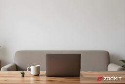 لپ‌تاپ و فنجان قهوه روی میز کار در محیط خانه