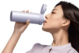 یک شخص با فلاسک شیائومی در حال نوشیدن مایعات