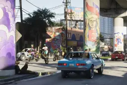خودروی آبی‌رنگ در خیابان پر از گرافیتی در محیط بازی GTA 6