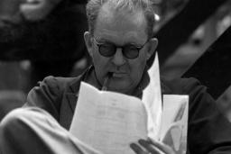 جان فورد (John Ford) با عینک در حال مطالعه برگه‌های کاغذ