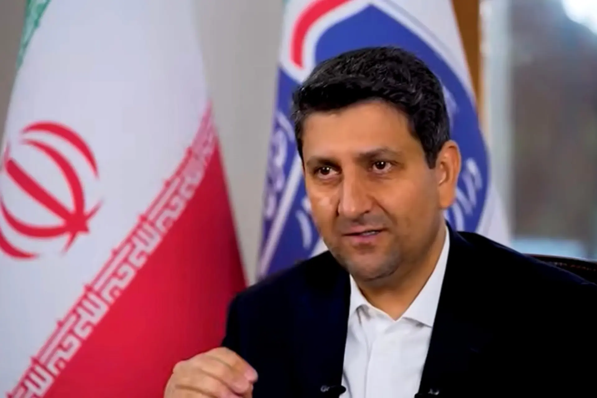وزیر ارتباطات ایران در مقابل پرچم‌های ملی و سازمانی