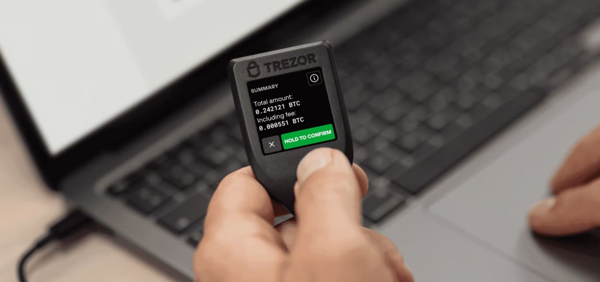 کیف پول سخت‌افزاری ارز دیجیتال Trezor Model T در دست مرد