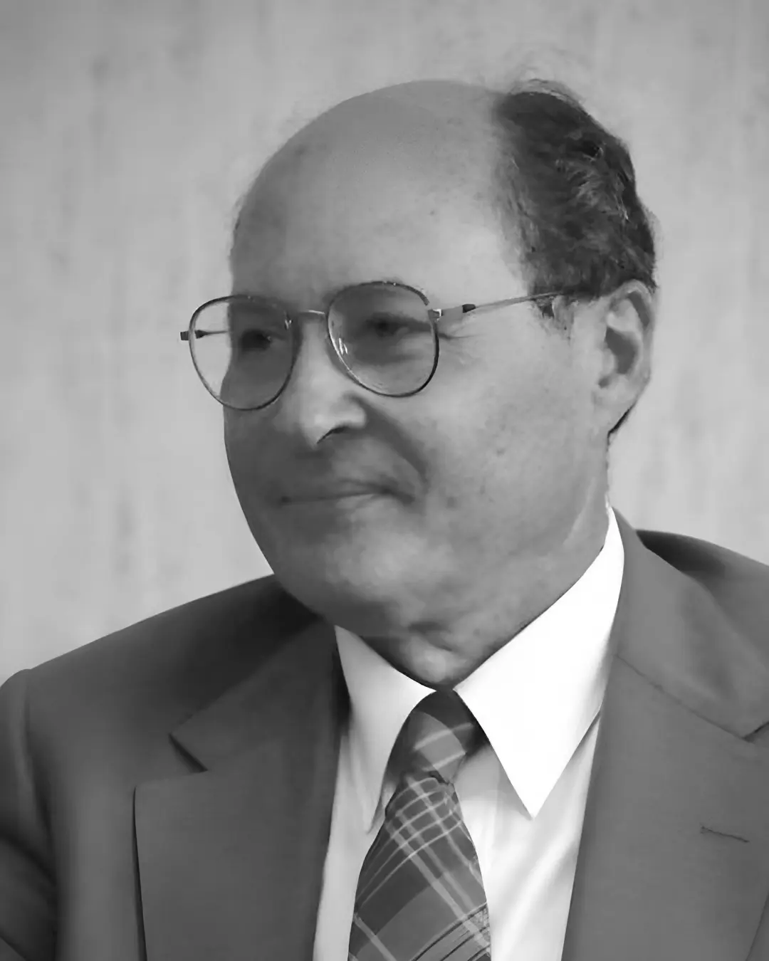 دنیل ناتانز (Daniel Nathans) با عینک و کت رسمی