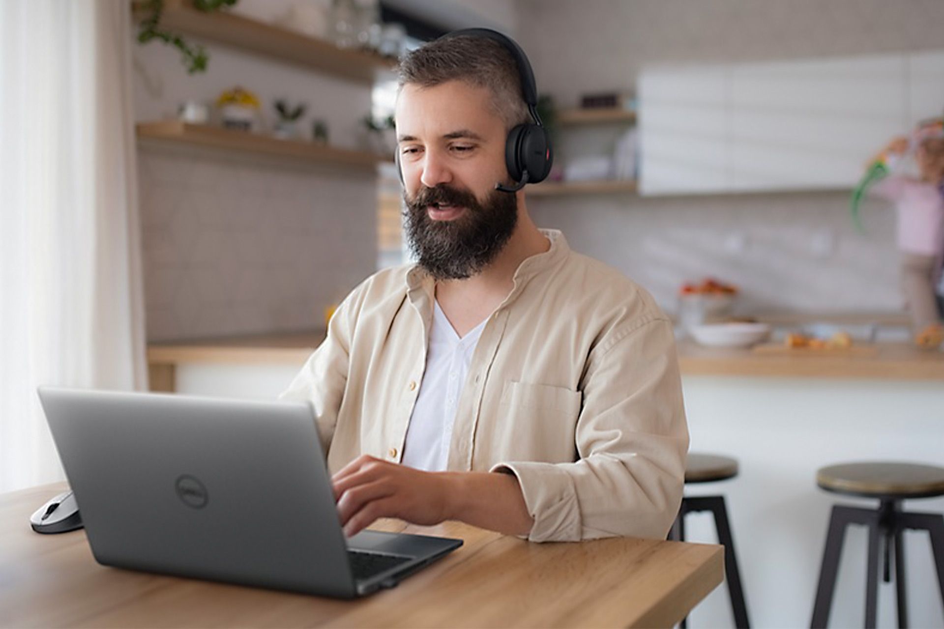 مردی در حال کار با هدست ANC و لپ تاپ دل 