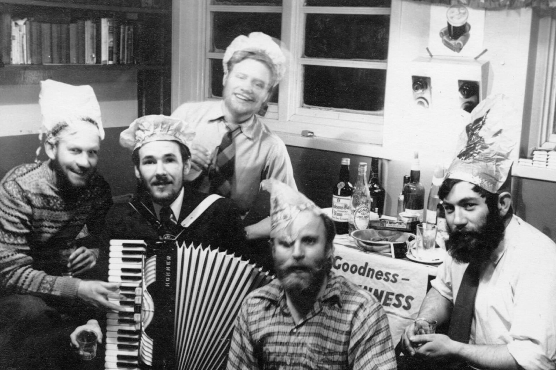 دنیس «تینک» بل (نفر سمت راست) در جریان جشن‌های کریسمس در ایستگاه خلیج ادمیرالتی در سال ۱۹۵۸