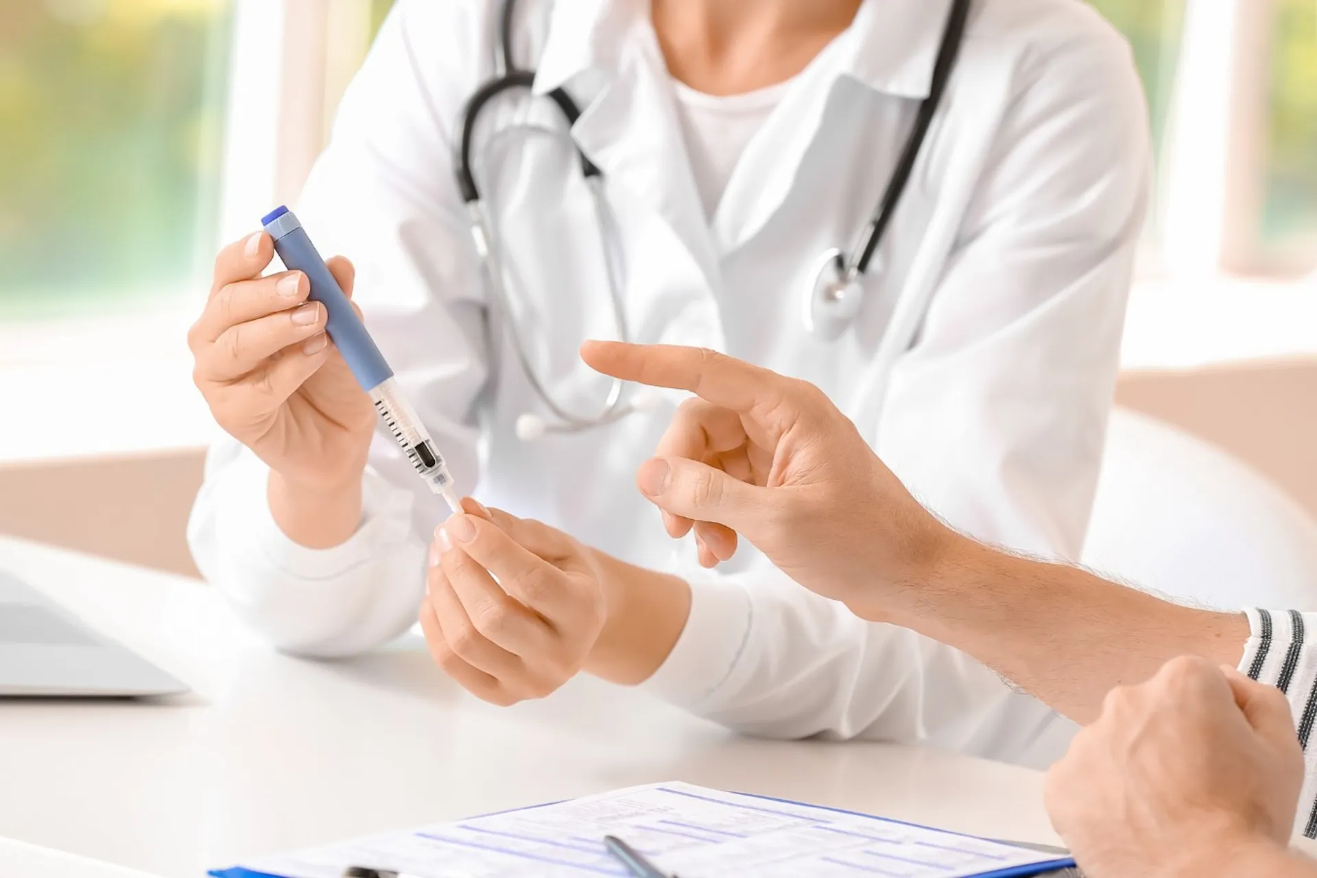 نمای نزدیک دست‌های پزشک و بیمار، بیمار آمپول برای تزریق در دست دارد.