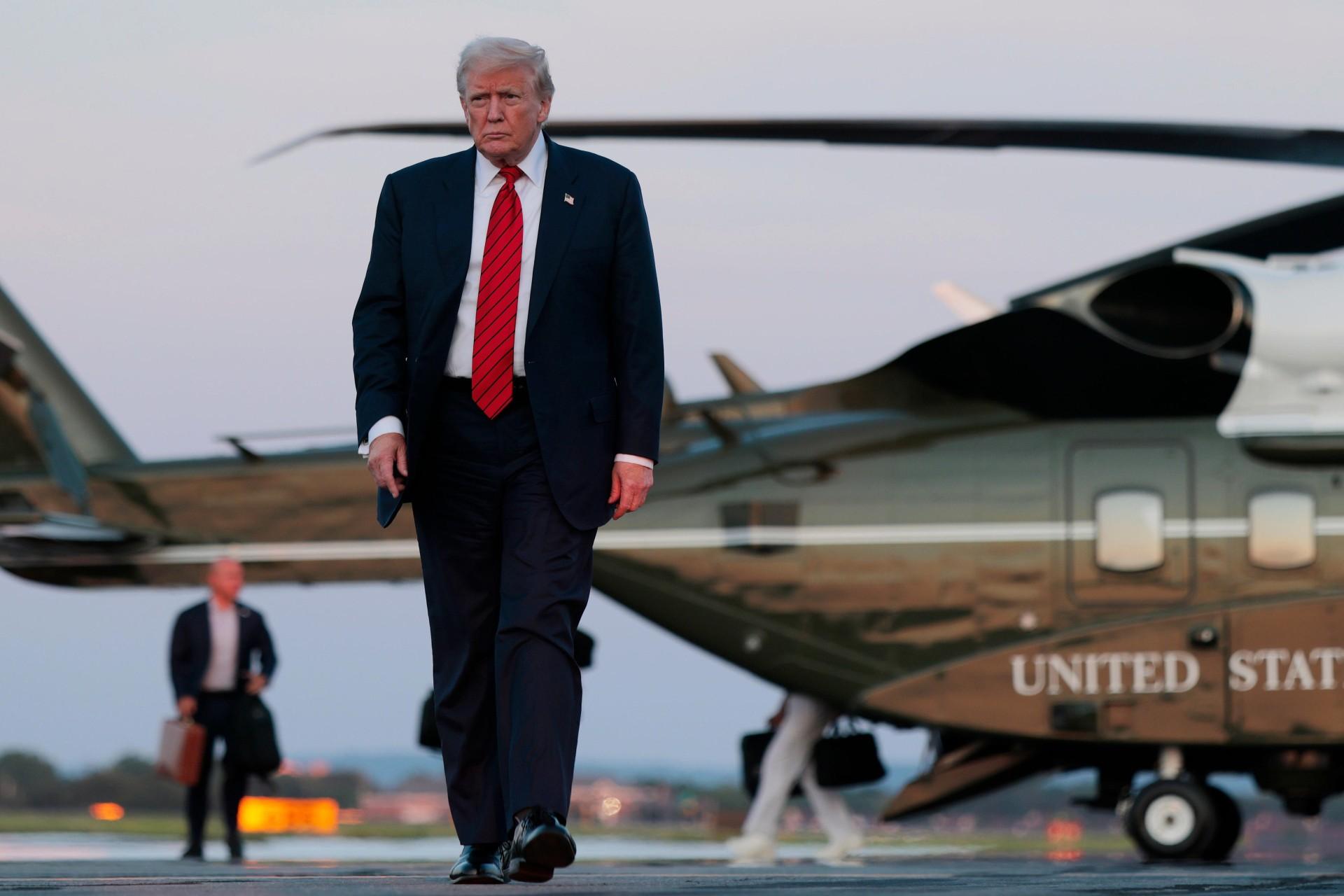 یک مرد با کت‌وشلوار در حال راه‌رفتن در باند فرود هلیکوپتر