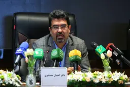 دکتر احسان مصطفوی (Ehsan Mostafavi) پشت میز کنفرانس و میکروفون‌ها