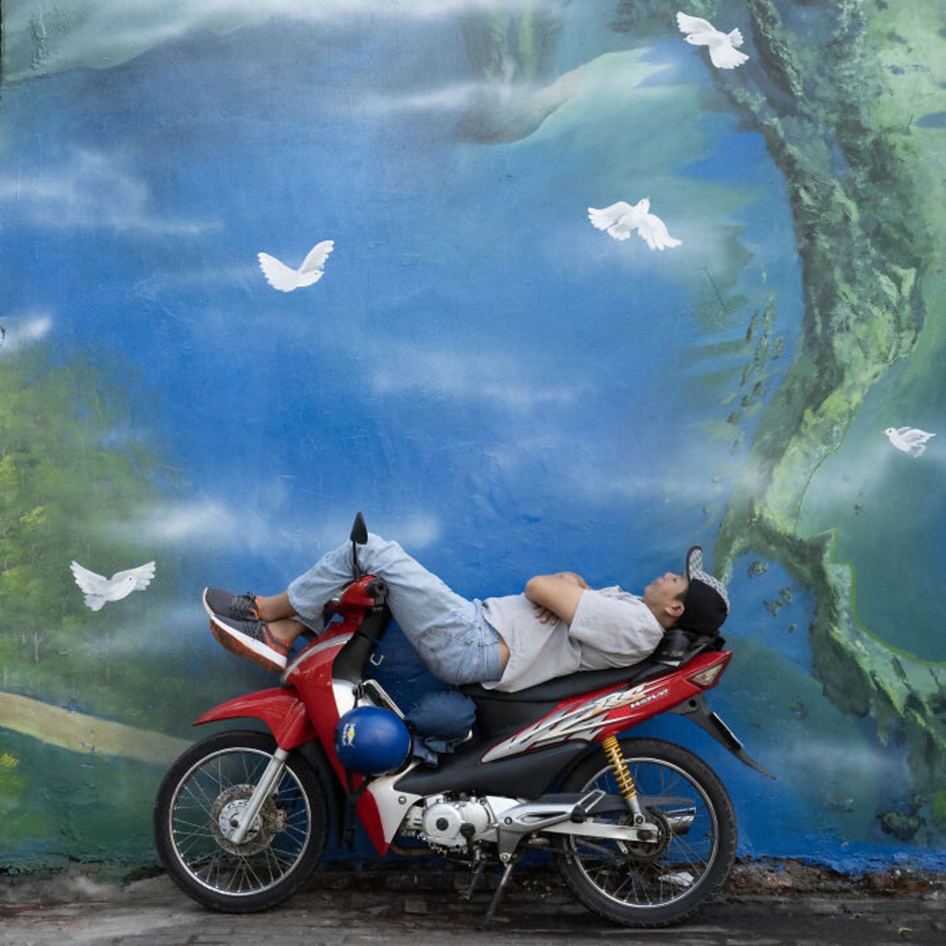 مرد خوابیده روی موتورسیکلت